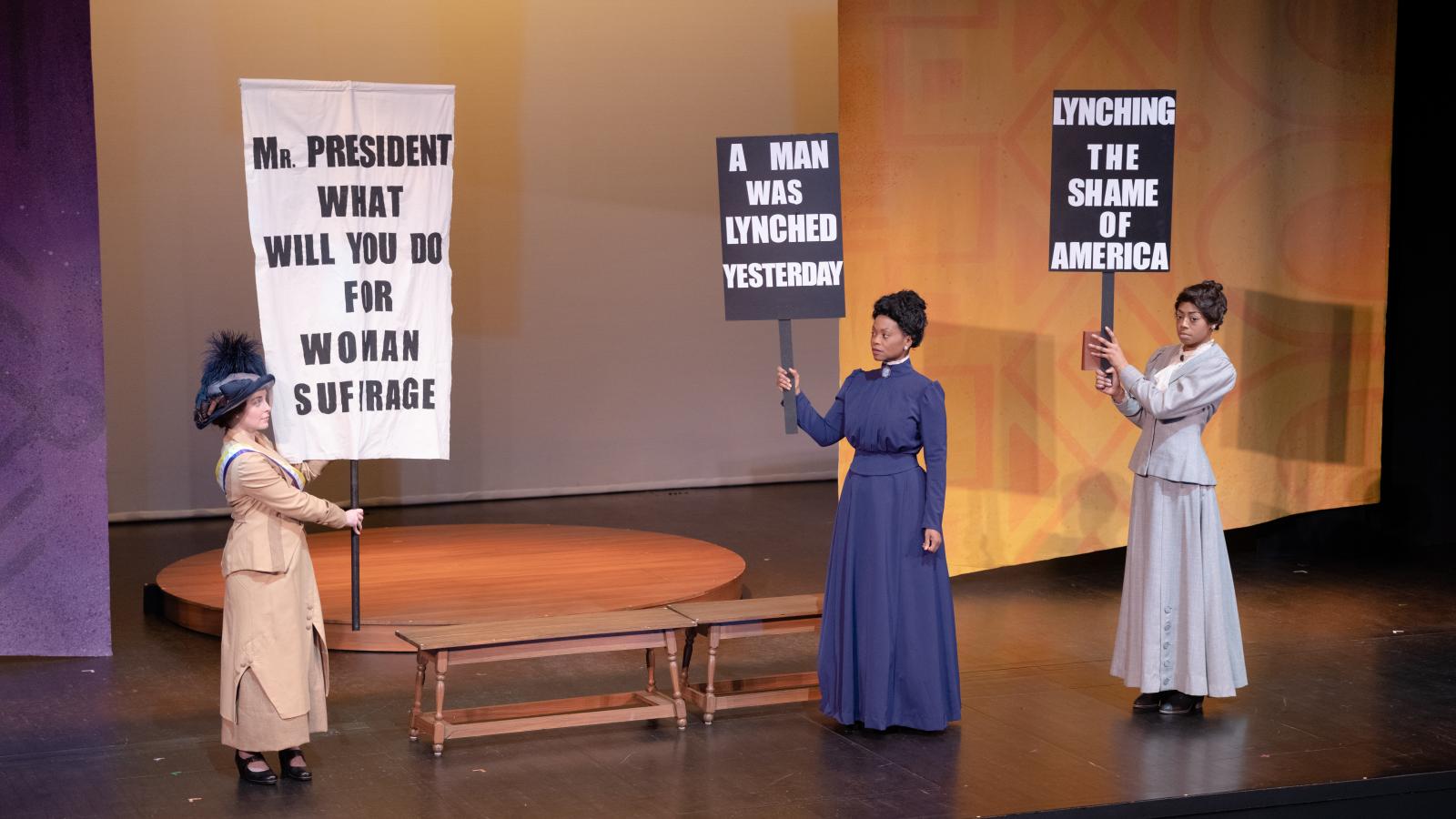 Actresses hold up picket signs about suffrage and lynching
